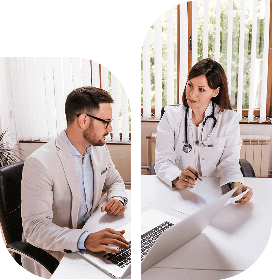 A doctor and a patient sit across from each other at a desk in an office, discussing paperwork. The doctor is wearing a white coat and stethoscope; the patient is using a laptop.